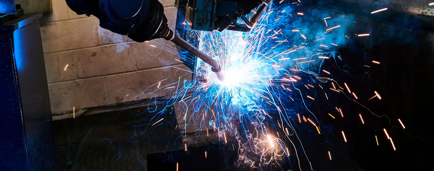 A welder at work in one of Newfield's welding bays